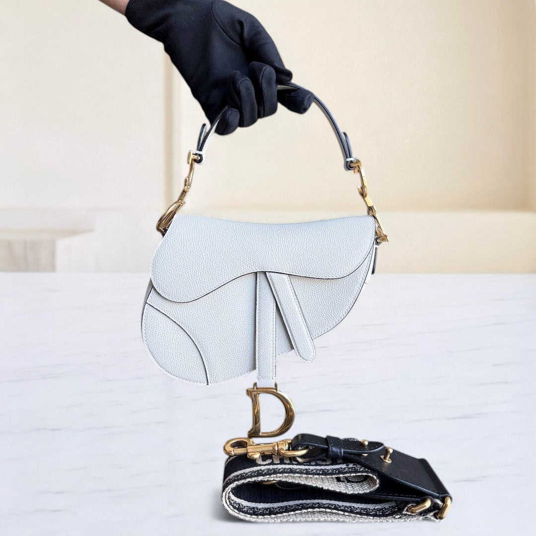 Kovancy Saddle Small 21 cm en cuir caviar blanc avec bandoulière et finitions dorées.