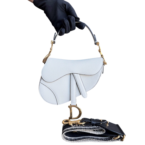 Kovancy Saddle Small 21 cm en cuir caviar blanc avec bandoulière et finitions dorées.