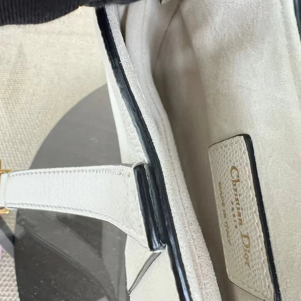 Kovancy Saddle Small 21 cm en cuir caviar blanc avec bandoulière et finitions dorées.